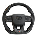 Carbon fiber steering wheel with Toyota logo on a white background