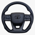 Black steering wheel with Toyota logo on a white background